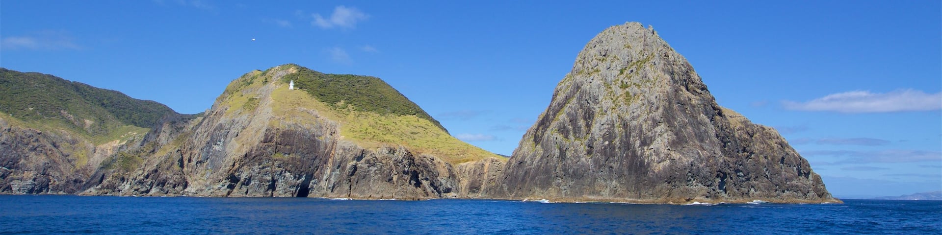 Cape Brett Lighthouse ofreciendo costa rocosa y una bahía o puerto