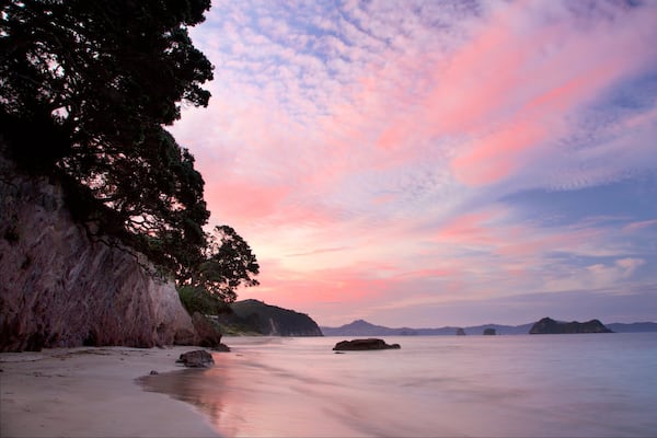 Plage de Hahei qui includes baie ou port, plage et coucher de soleil