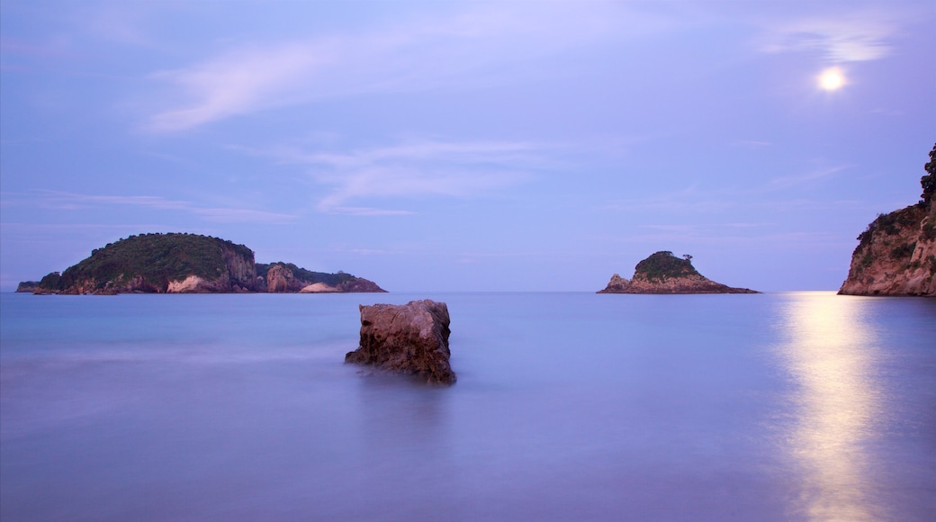 Hahei Beach das einen Inselansicht, Bucht oder Hafen und Sonnenuntergang