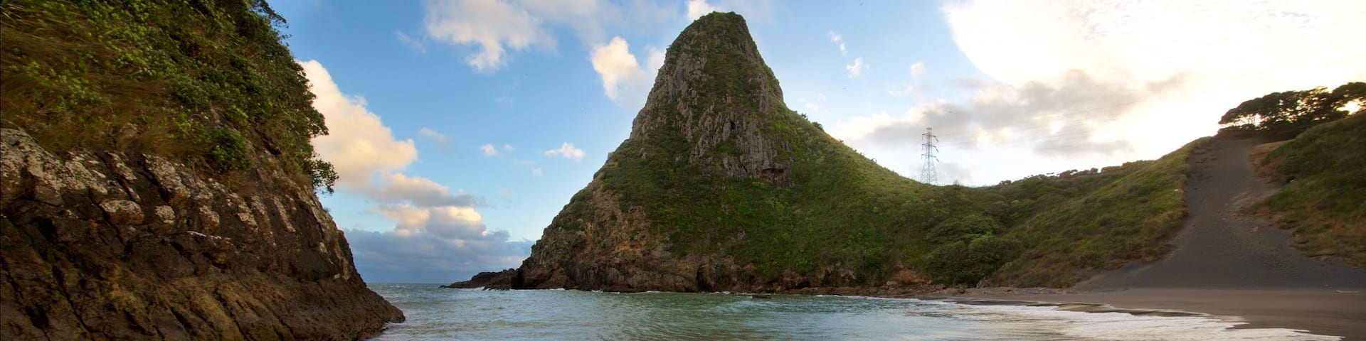 Paritutu Rock welches beinhaltet Strand, Sonnenuntergang und Bucht oder Hafen