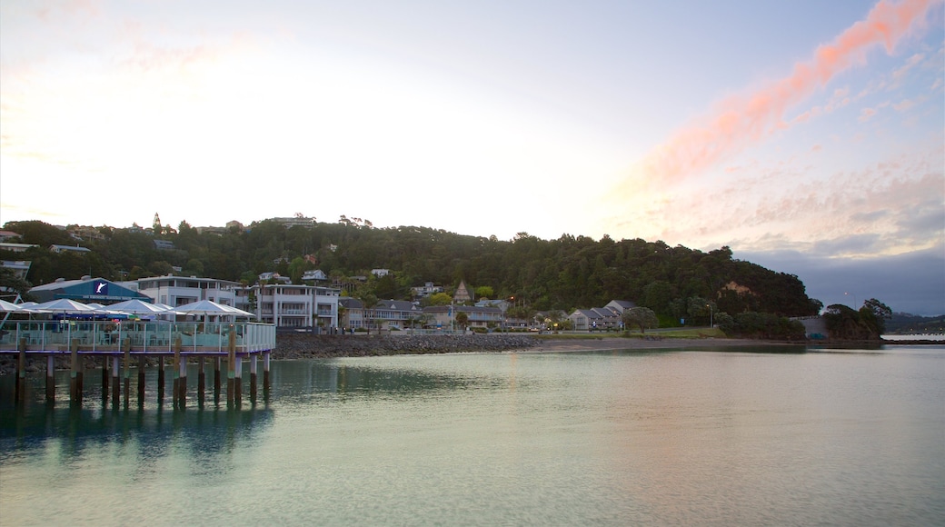 Paihia Wharf som inkluderar en solnedgång, en kuststad och en hamn eller havsbukt