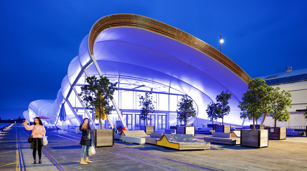 Queens Wharf featuring modern architecture and night scenes as well as a couple