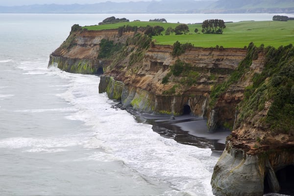 New Plymouth welches beinhaltet Felsküste, Brandung und Bucht oder Hafen