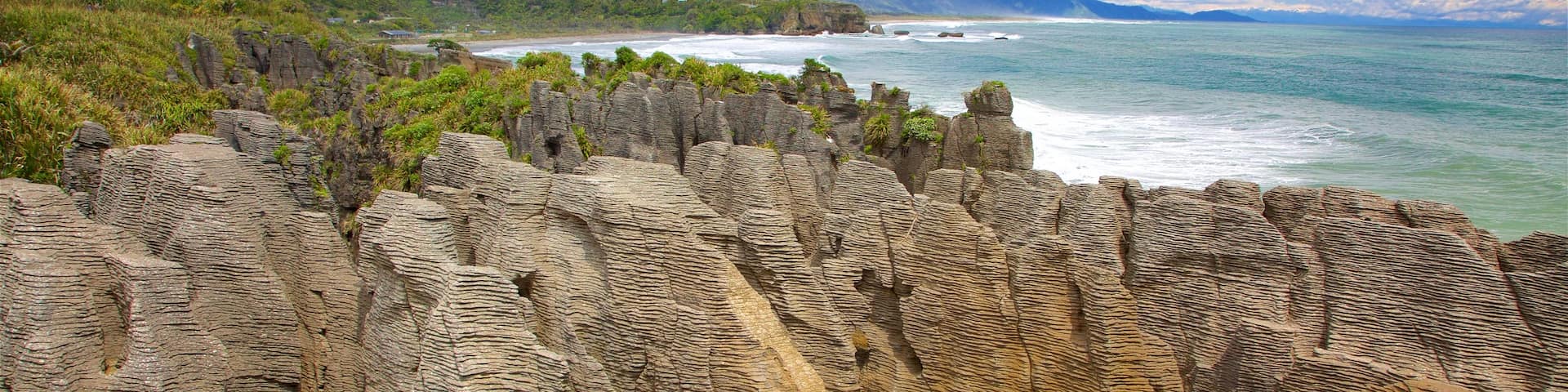 West Coast New Zealand featuring a bay or harbor, mountains and rugged coastline