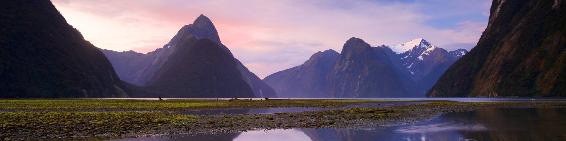 Milford Sound showing a sunset, a lake or waterhole and mountains