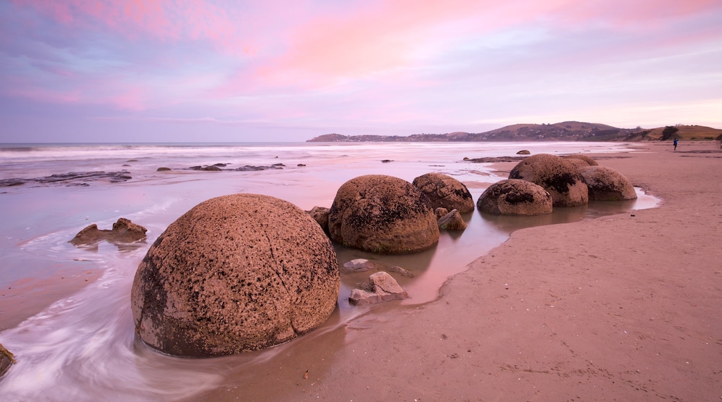 Moeraki Boulders toont ruige kustlijn, een zonsondergang en een strand