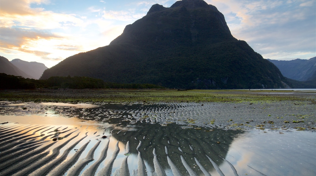 Milford Sound som visar en solnedgång, en sjö eller ett vattenhål och berg