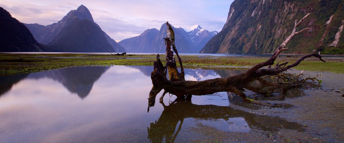 Mitre Peak featuring a bay or harbour, mountains and a sunset