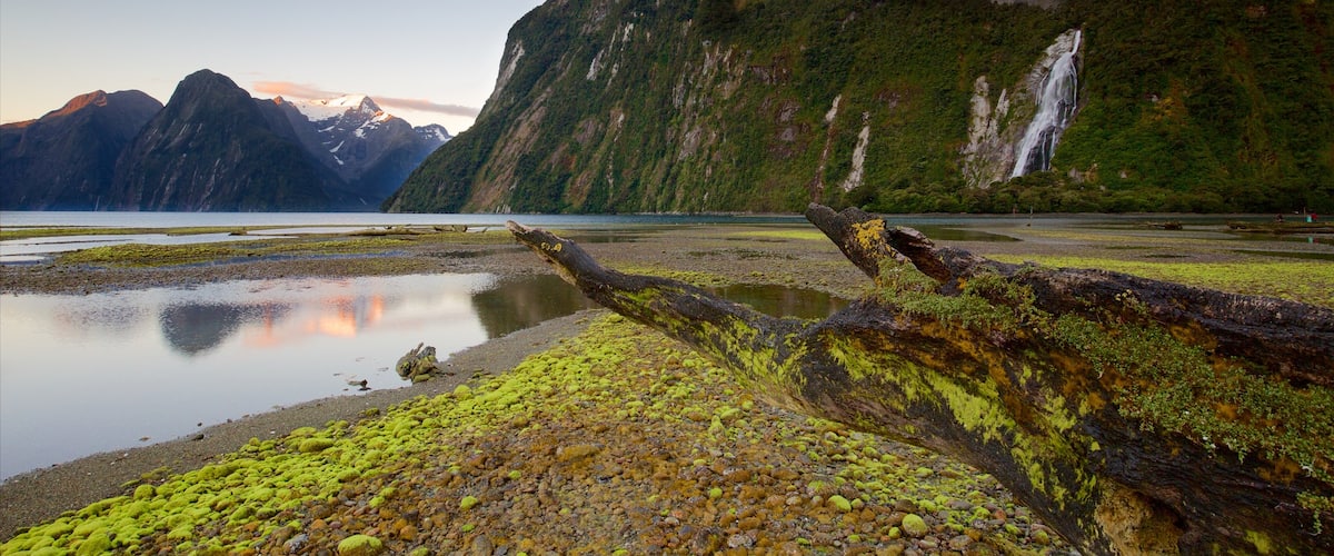 Fiordland National Park featuring a sunset, mountains and a waterfall
