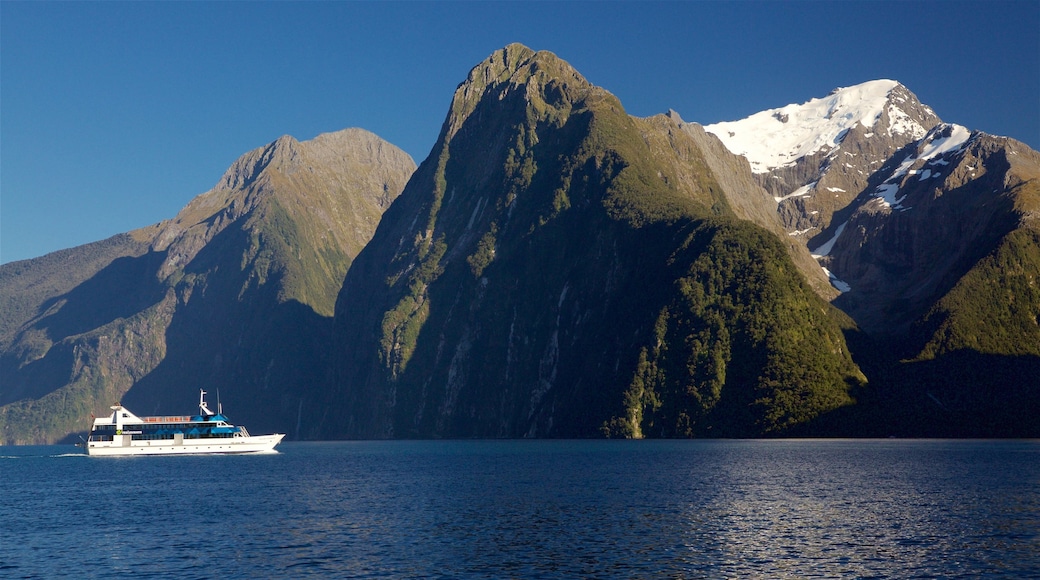 Parque nacional de Fiordland que incluye una bahía o puerto, montañas y paseos en lancha