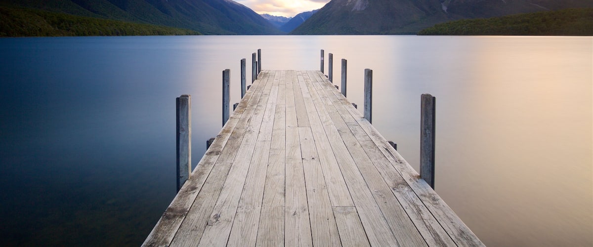 Nelson Lakes National Park mostrando montañas, una puesta de sol y una bahía o puerto