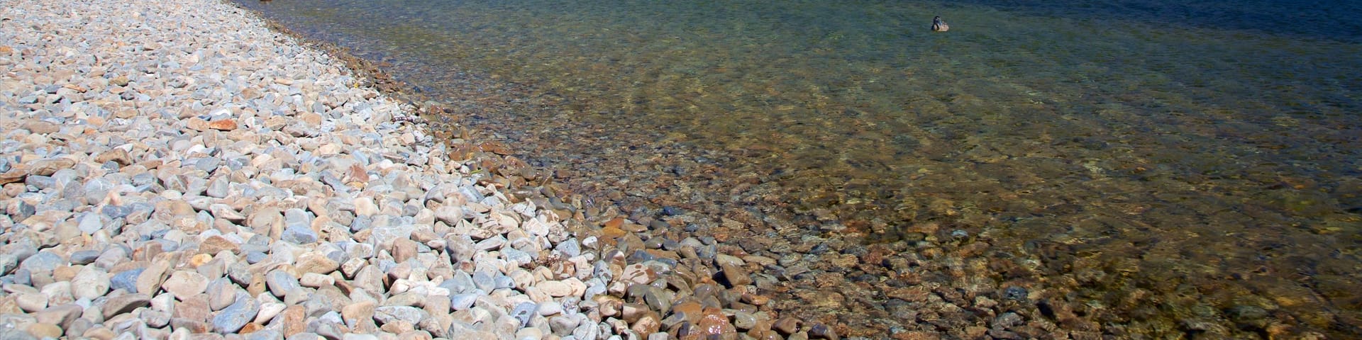Nelson Lakes National Park featuring a bay or harbour, a pebble beach and mountains