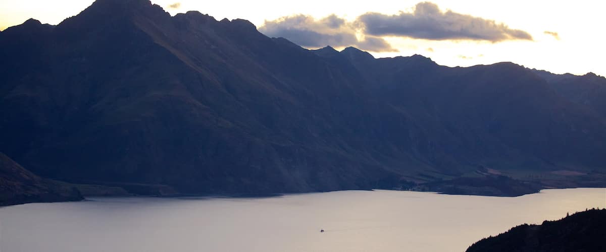 Sunshine Bay which includes mountains, a lake or waterhole and a sunset