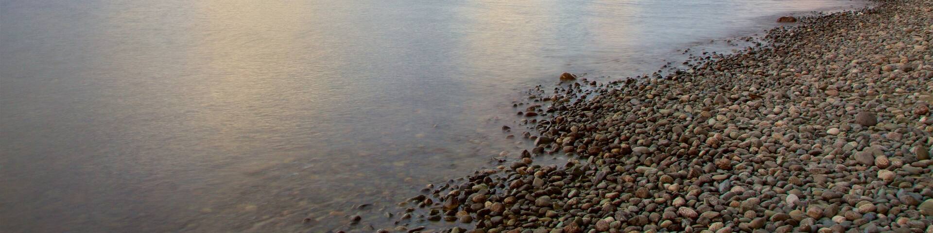 Lake Te Anau showing mountains, a lake or waterhole and a sunset