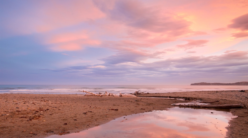 Oamaru showing general coastal views, a sandy beach and a sunset