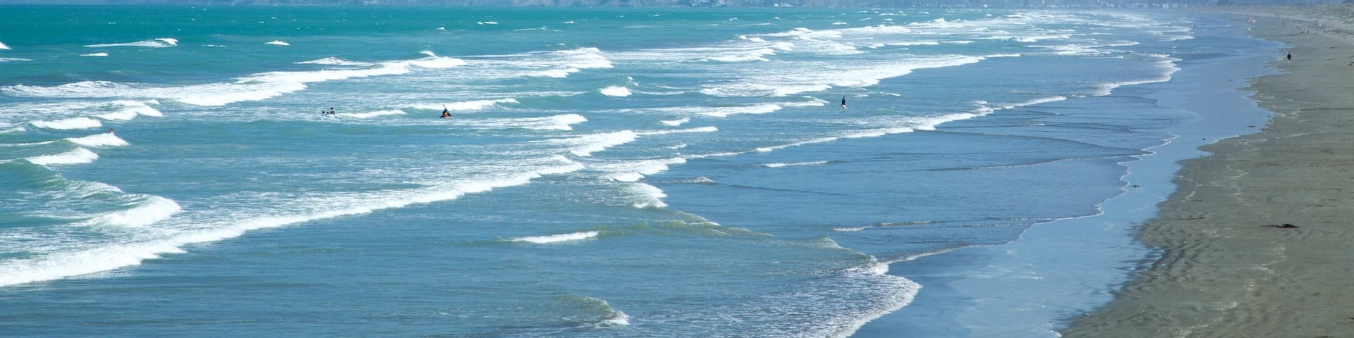 New Brighton Beach showing surfing, a beach and a coastal town