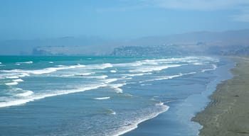 New Brighton Beach showing a coastal town, a sandy beach and surfing