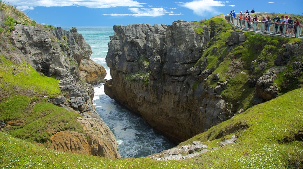 Pancake Rocks som inkluderer stenete kystlinje, bukt eller havn og utsikt