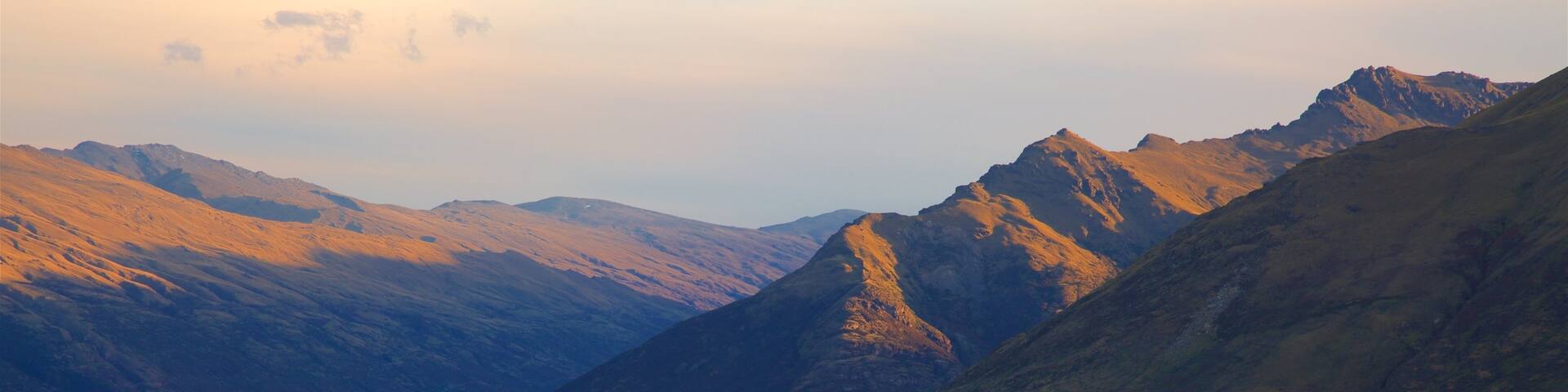Cecil Peak which includes a lake or waterhole, mountains and a sunset