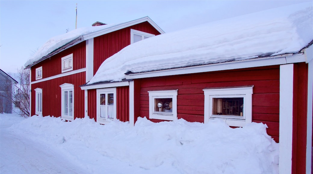 Gammelstads kyrka som inkluderar snö och ett hus