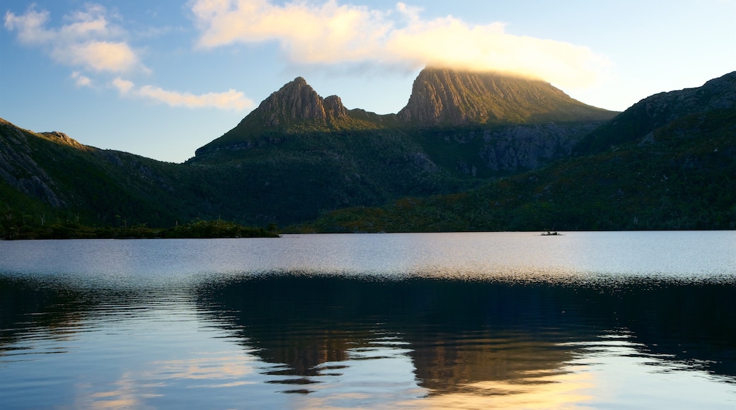 Cradle Mountain che include tramonto, montagna e lago o sorgente d\'acqua