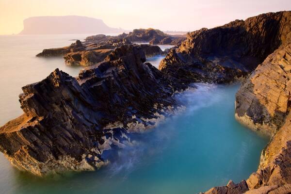 Stanley welches beinhaltet schroffe Küste, Sonnenuntergang und Bucht oder Hafen