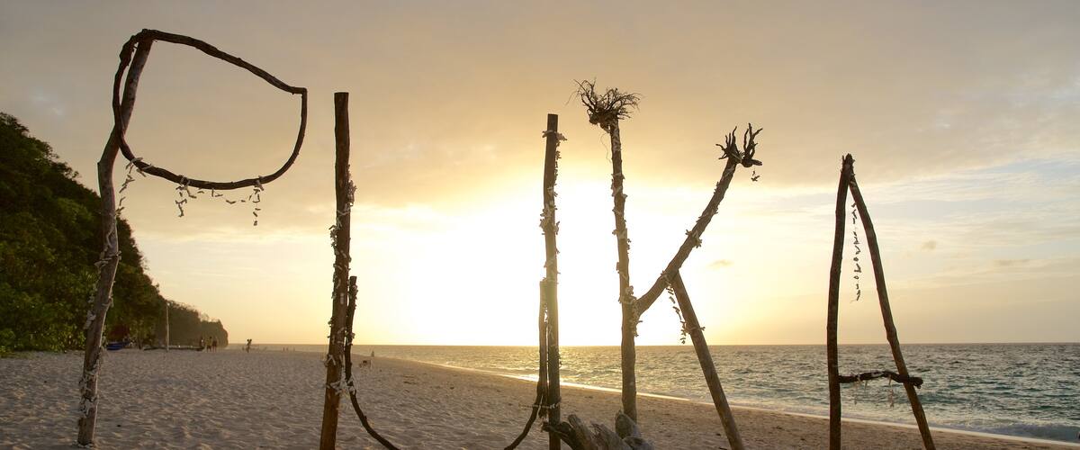 Plage de Puka mettant en vedette signalisation, scĂšnes tropicales et coucher de soleil