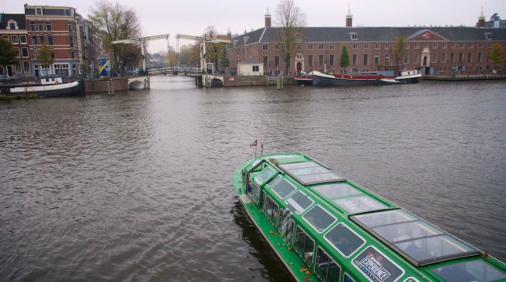 Magere Brücke mit einem Bootfahren, Fluss oder Bach und Kleinstadt oder Dorf