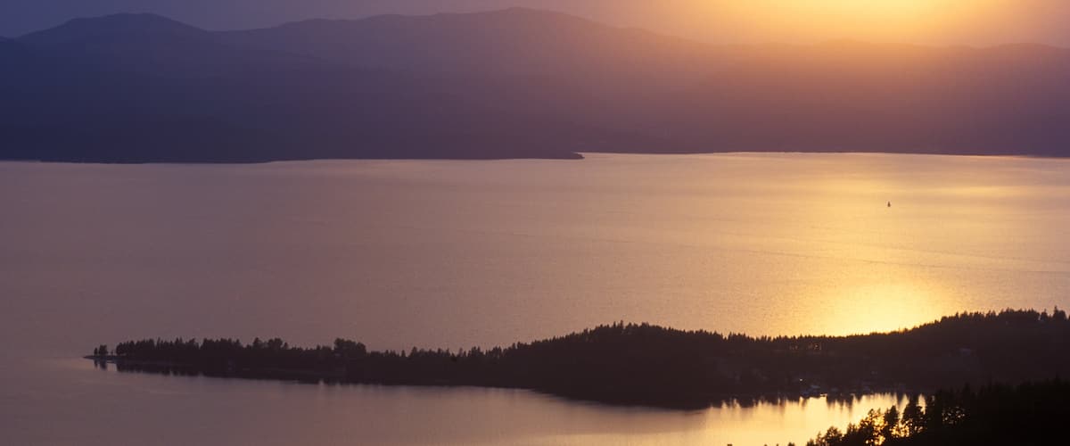 Flathead Lake mostrando un lago o abrevadero y una puesta de sol
