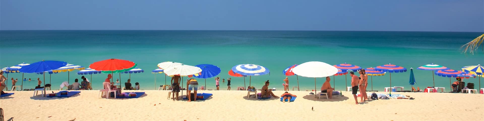 Surin qui includes une plage de sable et une plage de galets aussi bien que un petit groupe de personnes