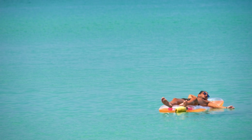 Strand von Surin welches beinhaltet Schwimmen und Bucht oder Hafen sowie einzelner Mann