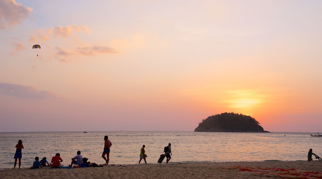 Playa Kata ofreciendo una playa de arena, un atardecer y una bahía o un puerto