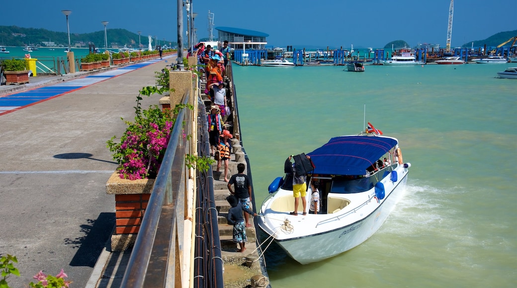 Chalong Pier which includes a bay or harbour and boating as well as a small group of people