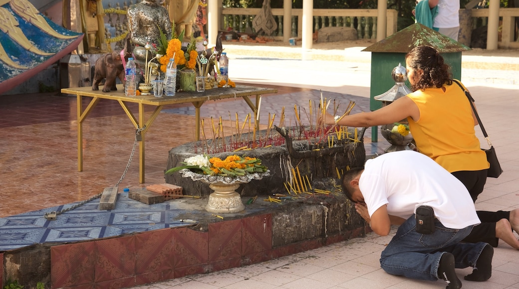 Muelle en la playa de Big Buddha mostrando aspectos religiosos y un templo o lugar de culto y también un grupo pequeño de personas