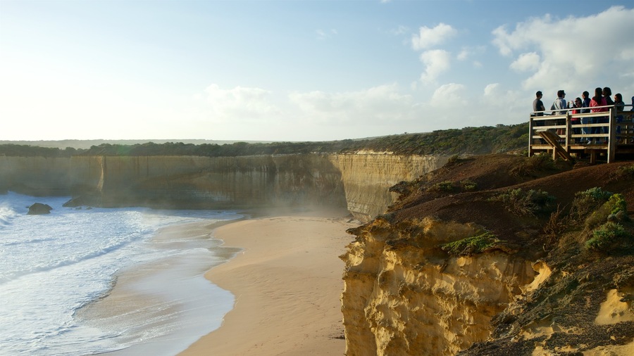 Port Campbell ofreciendo vistas y una playa de arena y también un grupo grande de personas