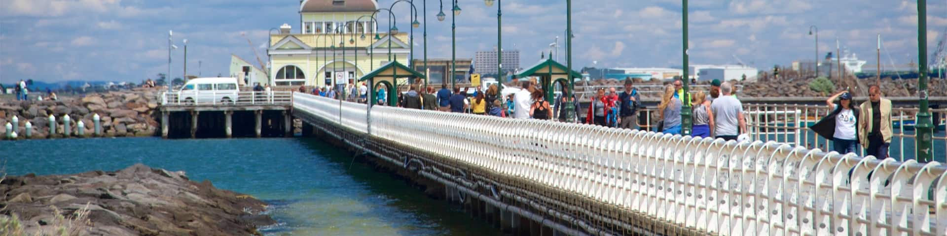 St Kilda Pier featuring heritage elements and a bay or harbor as well as a small group of people