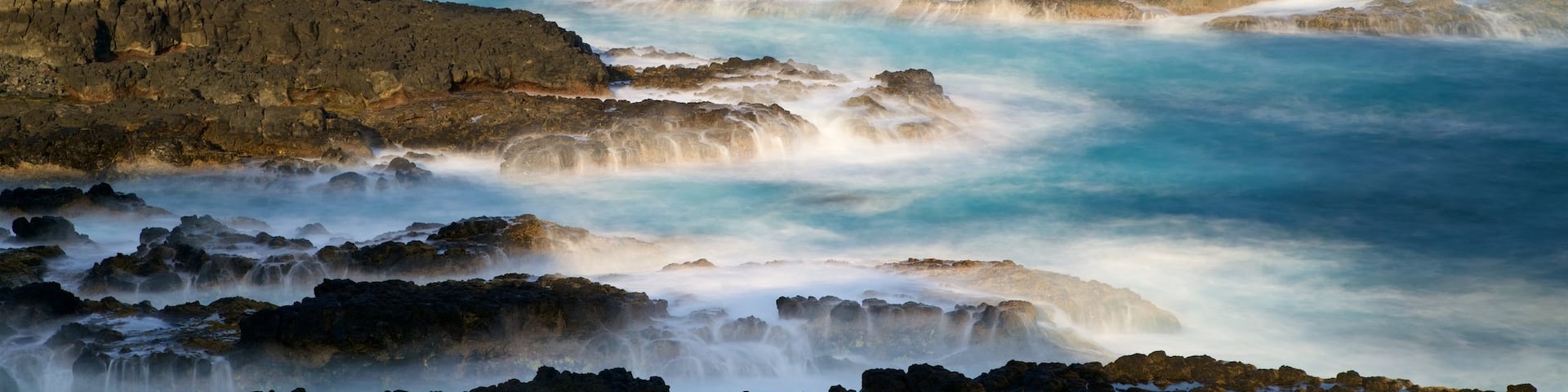 Phillip Island featuring rocky coastline, surf and a bay or harbor