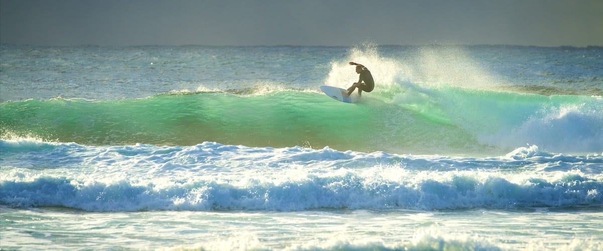 Blue Bay Beach featuring surfing, surf and a bay or harbor
