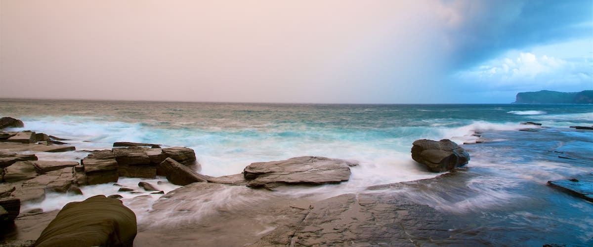 Australian Reptile Park featuring a sunset, a bay or harbor and rocky coastline