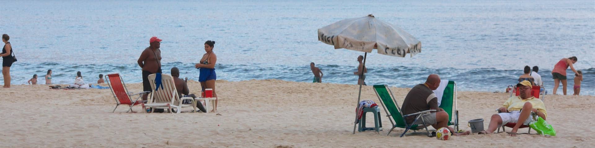Rio de Janeiro featuring general coastal views and a sandy beach as well as a large group of people