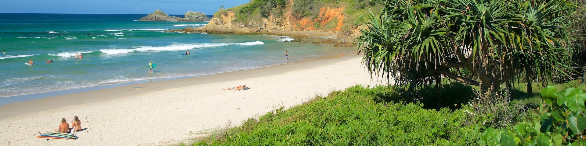 Broken Head featuring a bay or harbor, surf and rugged coastline