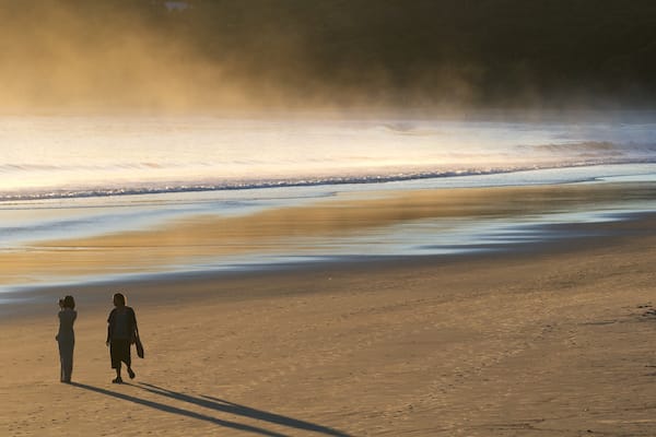 Main Beach which includes mist or fog and a beach as well as a couple