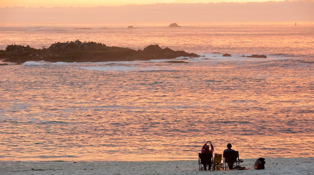 17-Mile Drive mostrando una puesta de sol y una playa de arena y también una pareja