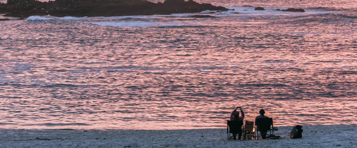 17-Mile Drive featuring a sunset and a beach as well as a couple