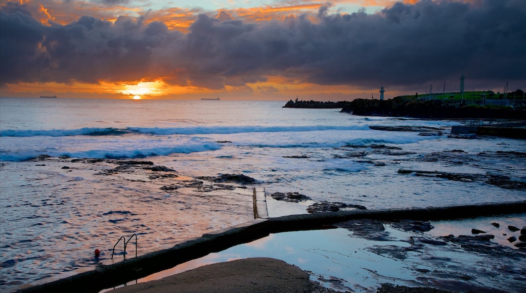 Wollongong North Beach which includes general coastal views, a sandy beach and a sunset