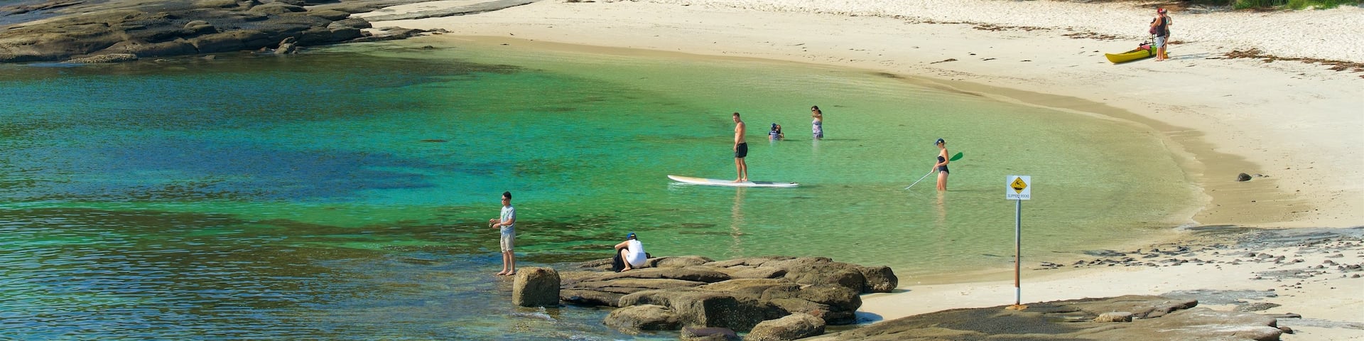 Huskisson featuring a sandy beach and general coastal views as well as a small group of people