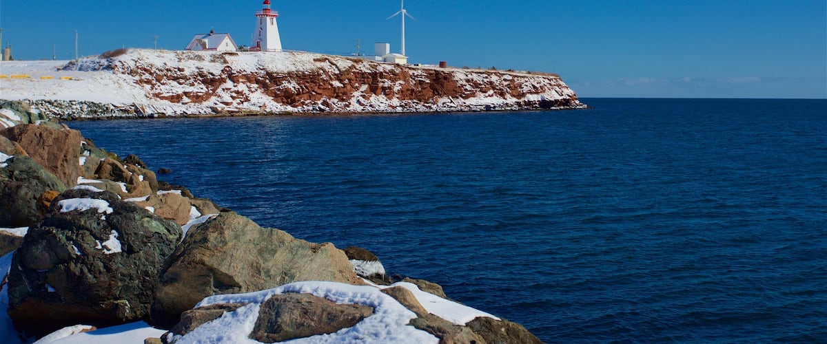 Souris Lighthouse which includes snow and a sandy beach