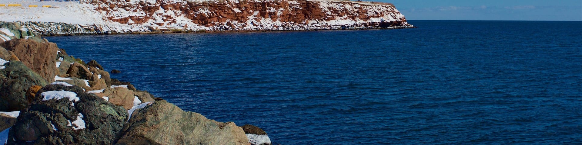 Souris Lighthouse which includes snow and a sandy beach