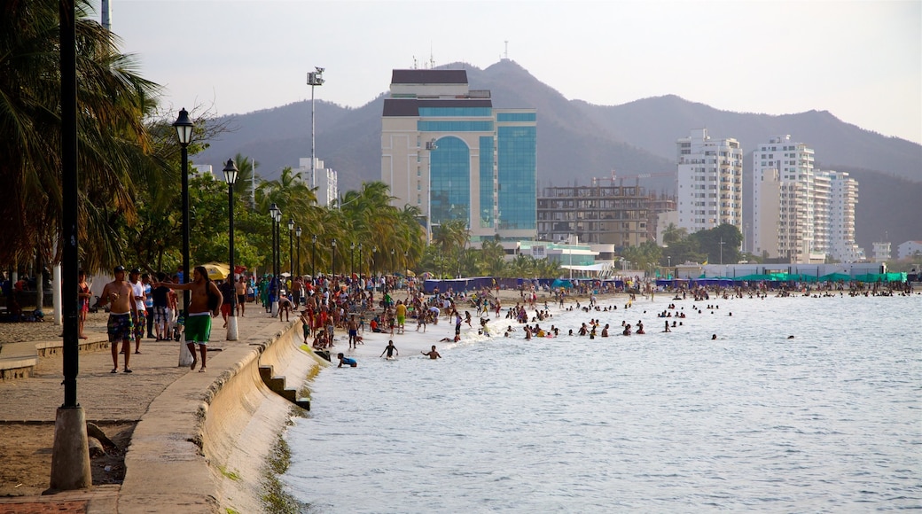 Costa Caribe which includes a skyscraper, a bay or harbour and swimming