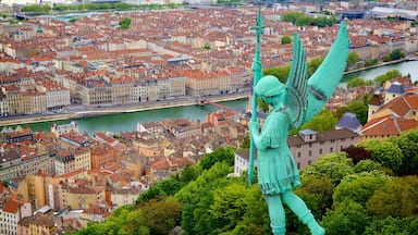 Lione mostrando fiume o ruscello, statua o scultura e città